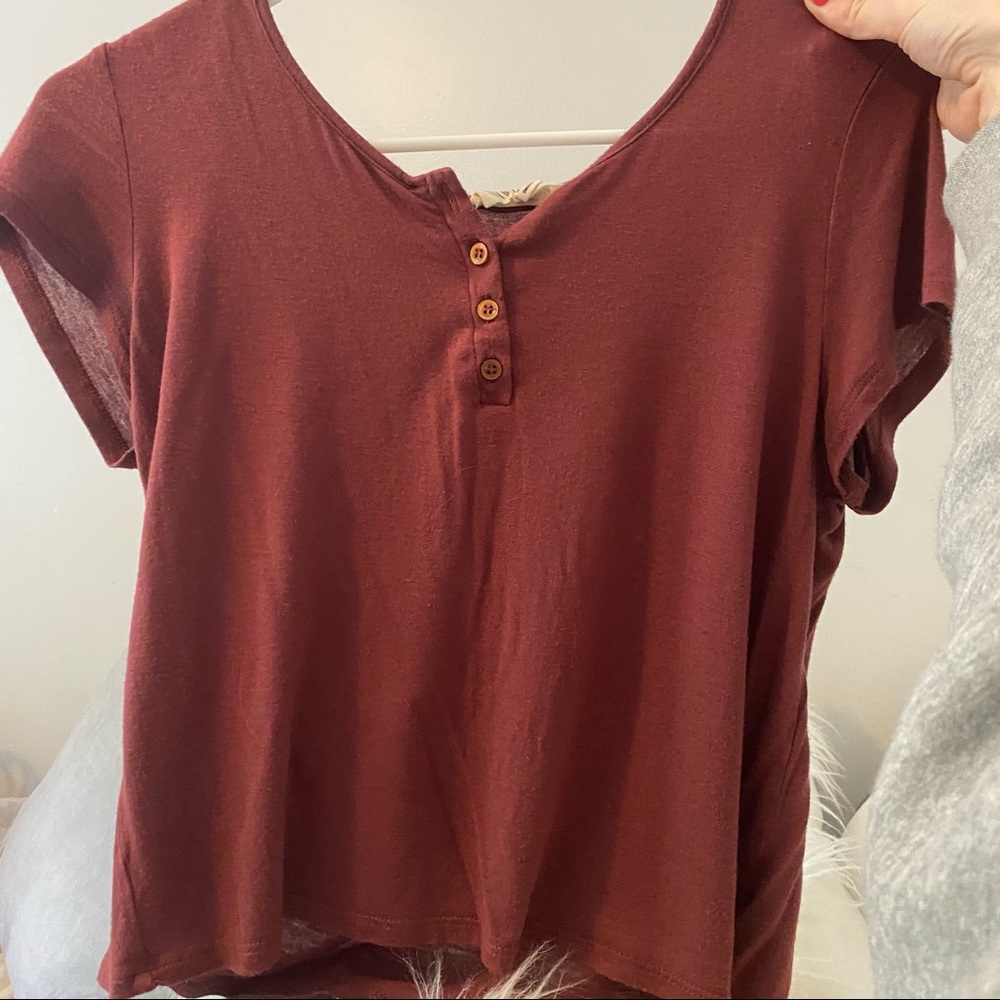 Short sleeve rust color with button details.